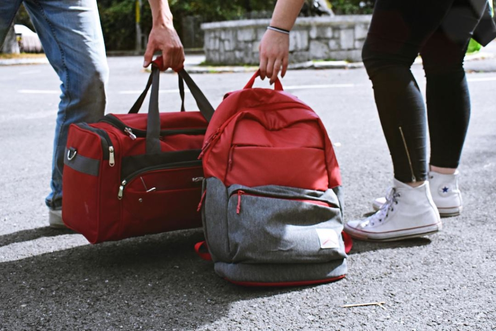 Personnes ramassant un sac à dos et bagage rouges