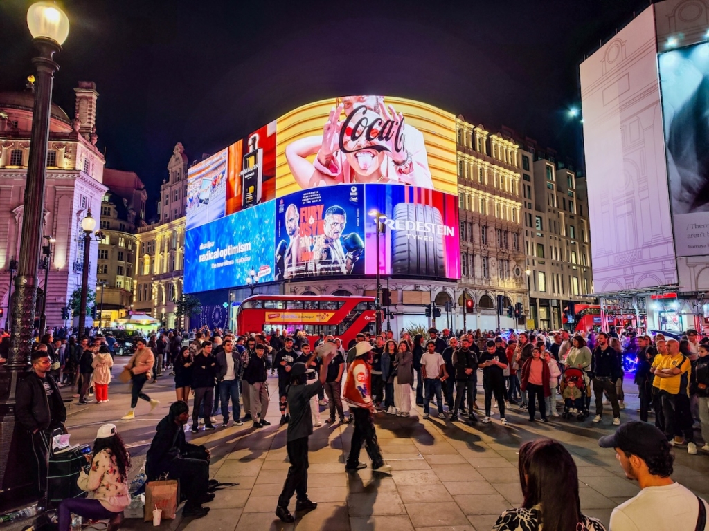 Le carrefour incontournable de Londres : Piccadilly Circus de nuit avec des spectacles de rue et ses écrans lumineux